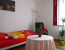 eeinzelschlafzimmer mit bett tisch stehlampe und relaxsessel sowie grosser zimmerpflanze