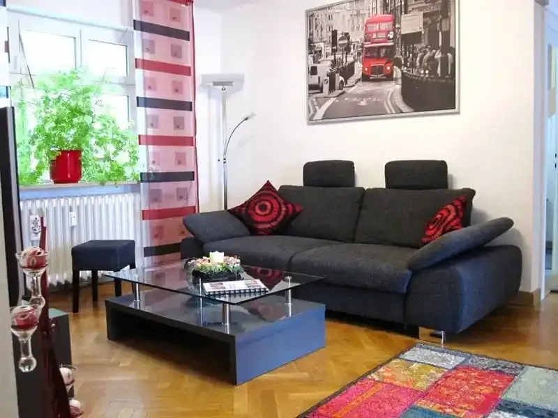 Wohndiele mit bequemer Couch einem Glastisch sowie einer Stehleuchte und großem Wandbild